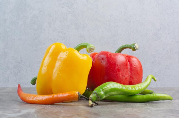 Tasty whole peppers on marble background. High quality photo