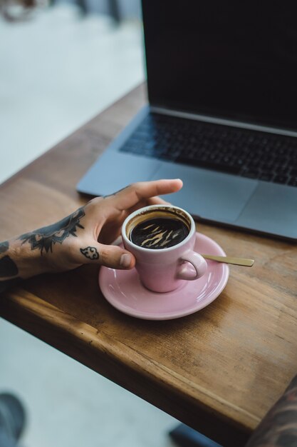 문신 된 손, 커피 및 노트북