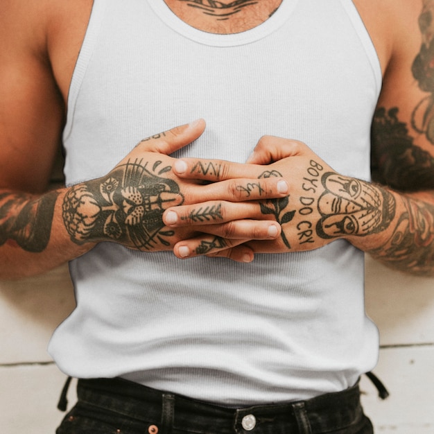 Free photo tattooed man clasping his hands on hit stomach while lying on the floor. 2 october 2020 - chippenham, uk