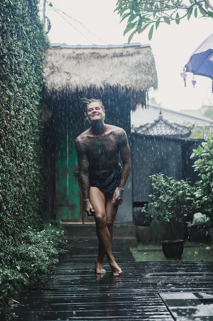 татуированный мужчина позирует в дождь
