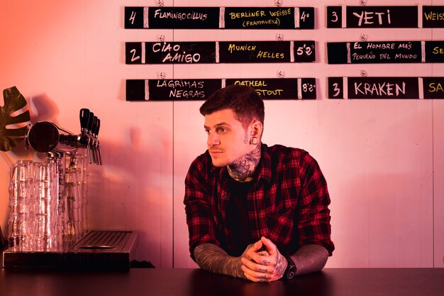Tattooed man waiting in bar