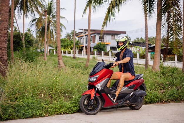 赤いバイクで熱帯のジャングルフィールドに入れ墨の強い男