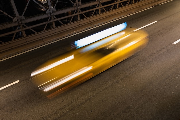 Free photo taxi on bridge at night with motion blur