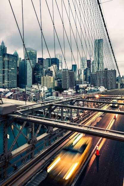 Taxi cab crossing the Brooklyn Bridge in New York, Manhattan skyline in background