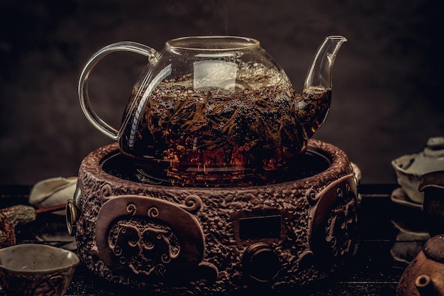 Tea ceremony concept. Close-up image of a process of brewing tea using the glass teapot.