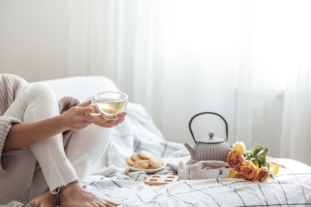 Tea, cookies and a bouquet of fresh tulips in bed copy space