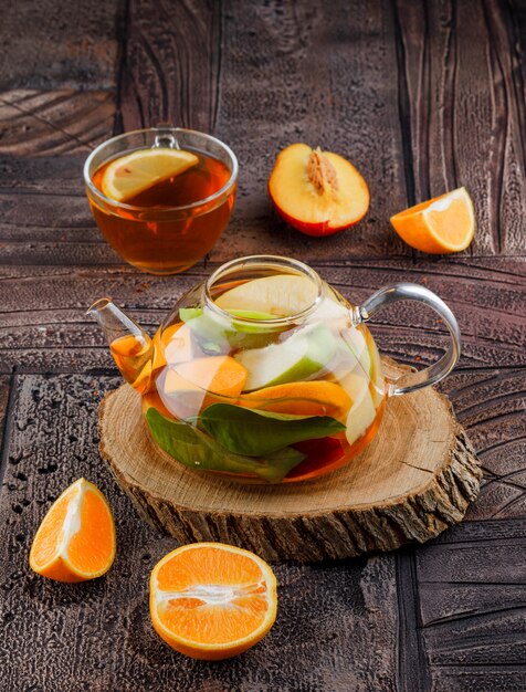 Tea in cup with fruits, fruit infused water wooden piece