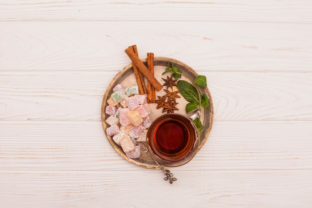Tea cup with Turkish delight and cinnamon on plate