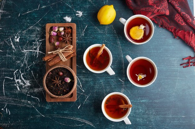 Tea cups with herbs and spices, top view.