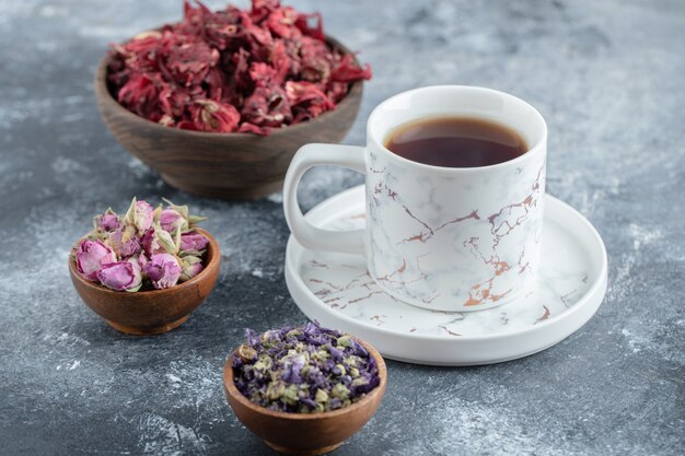 Tea and dried flowers on marble table.