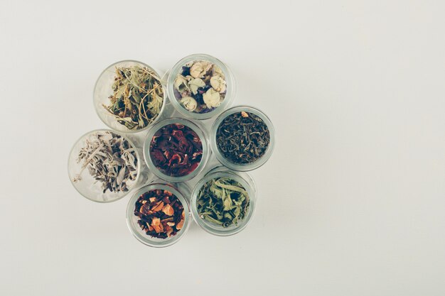 Tea flavors, dried herbs in small jars. flat lay.