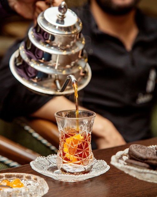 Tea is poured from steel teapot into crystal armudu glass