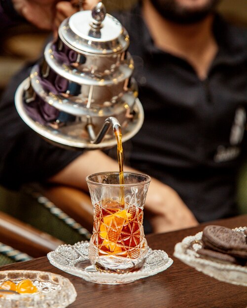 Tea is poured from steel teapot into crystal armudu glass