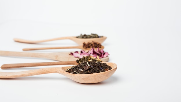 Foglie di tè sul cucchiaio di legno