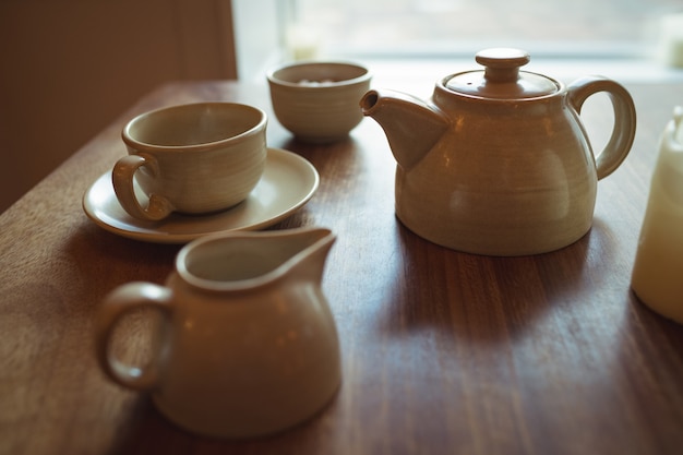 Tea pot and coffee cup on wooden table
