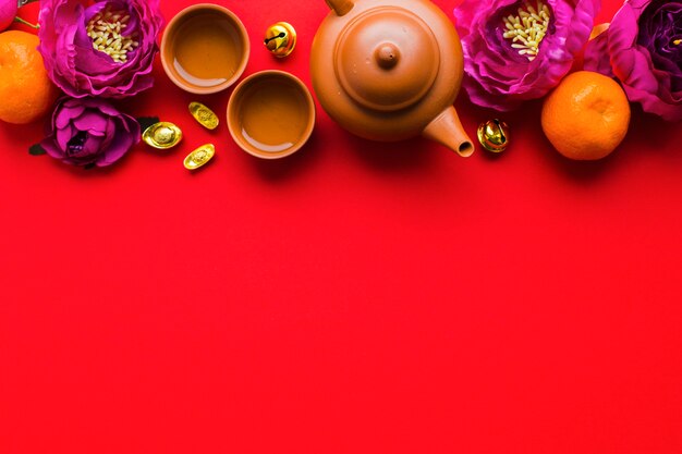 Tea set amidst flowers and tangerines