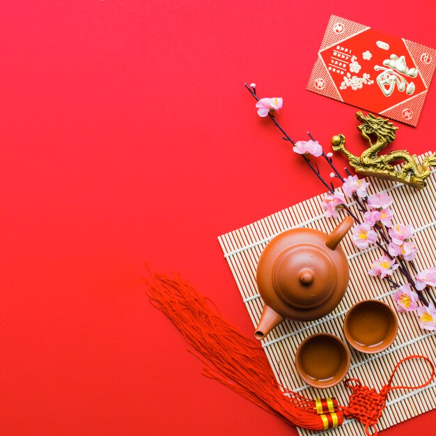 Tea set near branch and dragon statuette