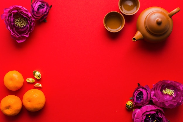 Tea set near flowers and tangerines