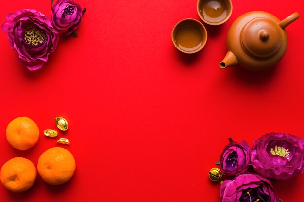 Tea set near flowers and tangerines