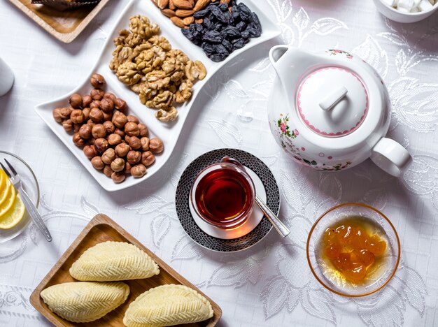 Tea set shakarbura white cherry jam nuts dry fruits tea in armudy top view