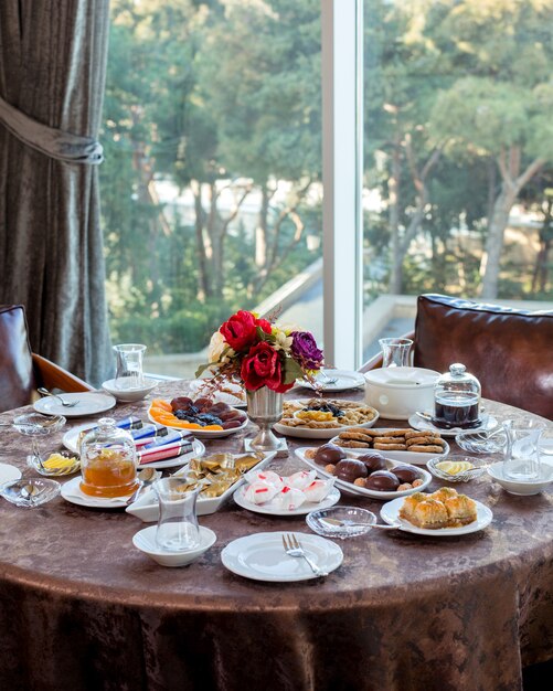 Tea set with candies, dried fruits and nuts, cookies, jams, lemon and baklava 1