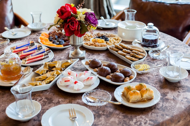 Tea set with candies, dried fruits and nuts, cookies, jams, lemon and baklava