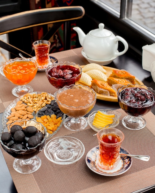 Free photo tea set with different types of jams, baklava, shekerbura, dry fruits and nuts