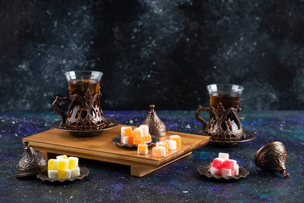 Tea set with Turkish delights on wooden board 