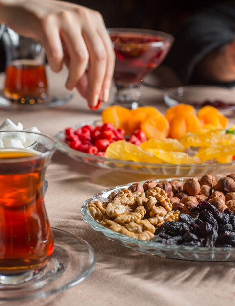 tea setup with black tea in armudu glass with dried furits and nuts