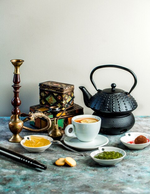 Tea setup with black of tea, teapot, hookah, jam