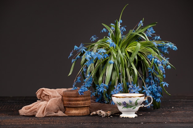 レモンとテーブルの上の青いサクラソウの花束とお茶