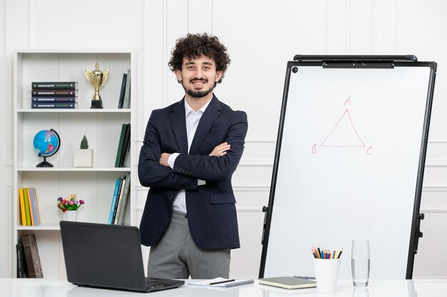 Teacher brunette instructor with computer in suit and whiteboard in classroom crossing hands