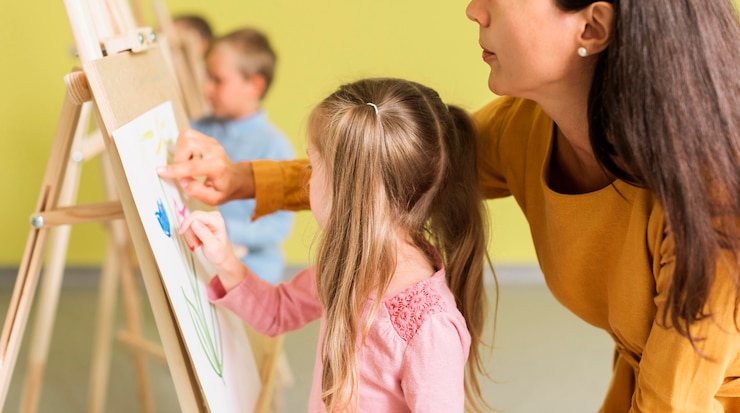 Free Photo teacher helping girl in drawing class
