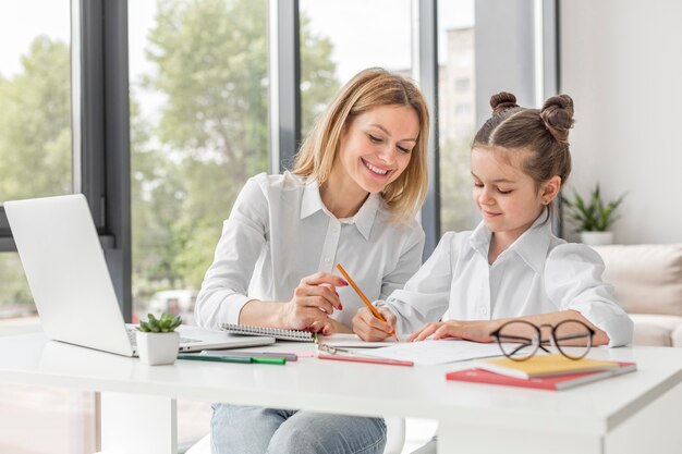 Teacher helping her daughter study at home