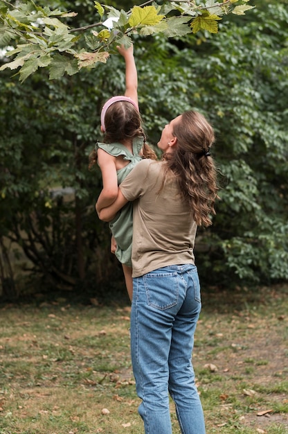 Free photo teacher holding little girl up