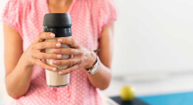 Insegnante che tiene un thermos con lo spazio della copia