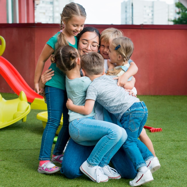 Free photo teacher hugging her students