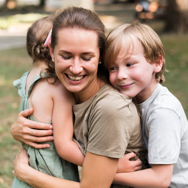 Teacher and kids hugging outdoors