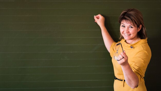 Teacher pointing at chalkboard with copy-space