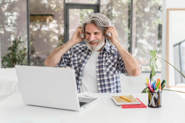 Teacher putting on headphones at desk