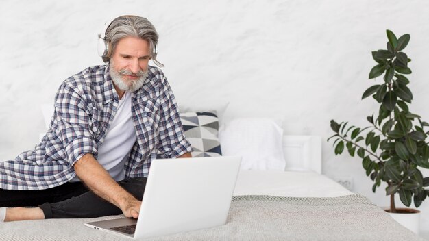 Free photo teacher sitting on bed using laptop