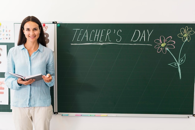 Free photo teacher standing next to a blackboard with copy space