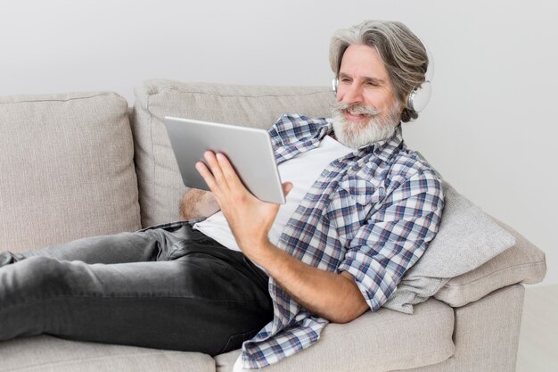 Teacher staying on couch looking at tablet