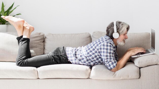 Free Photo teacher staying on couch using laptop