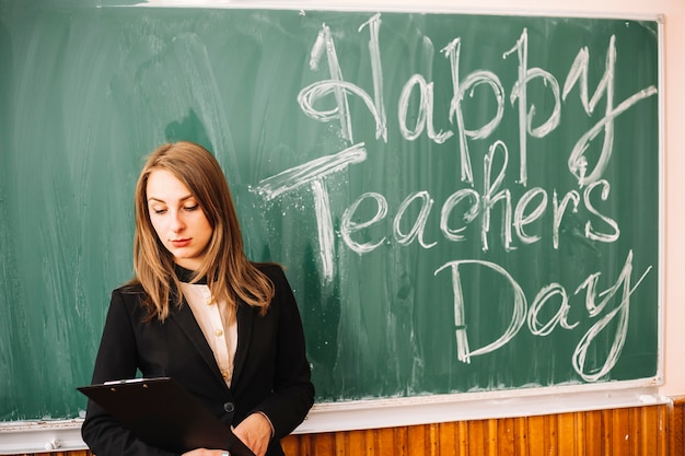 Free photo teacher staying near chalk board