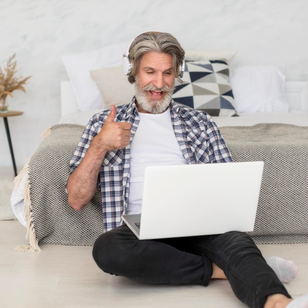 Free photo teacher talking at laptop sitting on floor