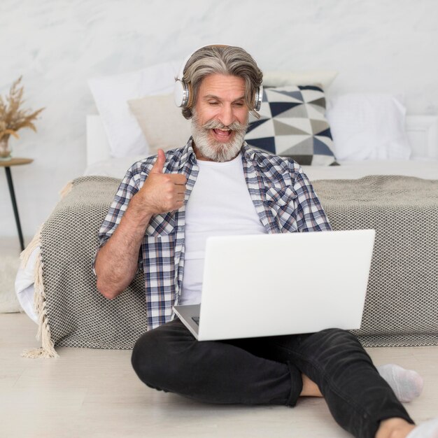 Teacher talking at laptop sitting on floor