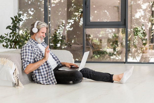 Free photo teacher using laptop sitting on floor