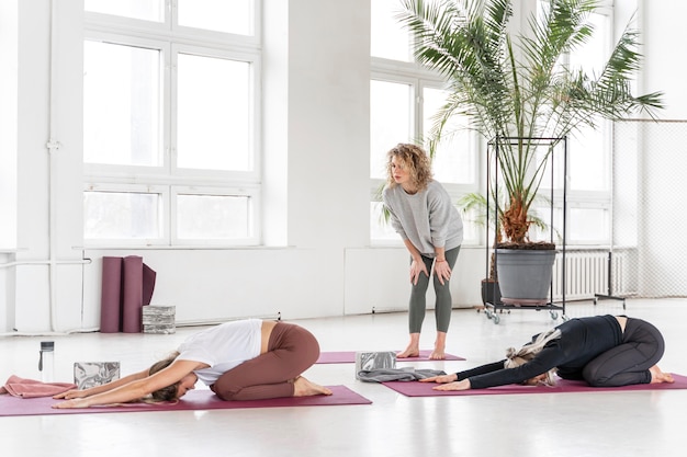 Free photo teacher watching women stretching