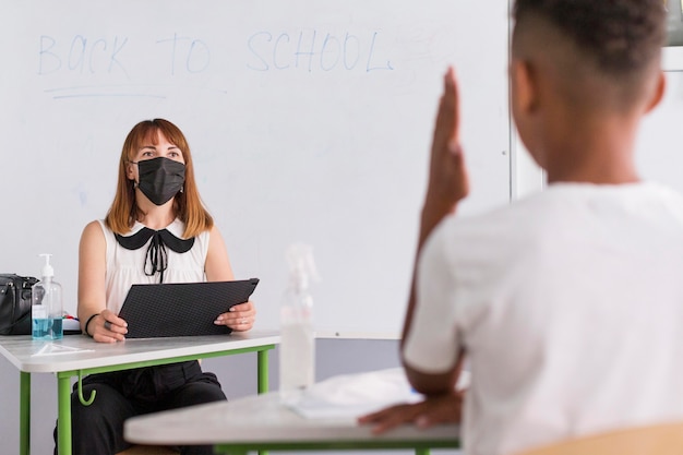 Free photo teacher with medical mask waiting for an answer